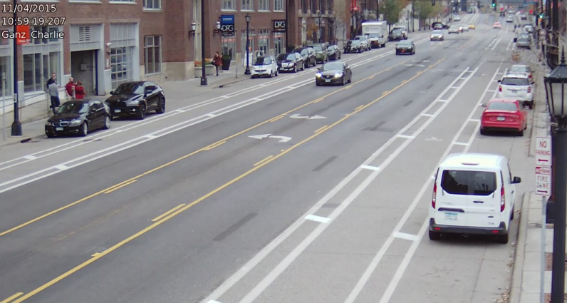 Image of a two-way, one lane street with a center turn lane and buffered bike lanes on either side